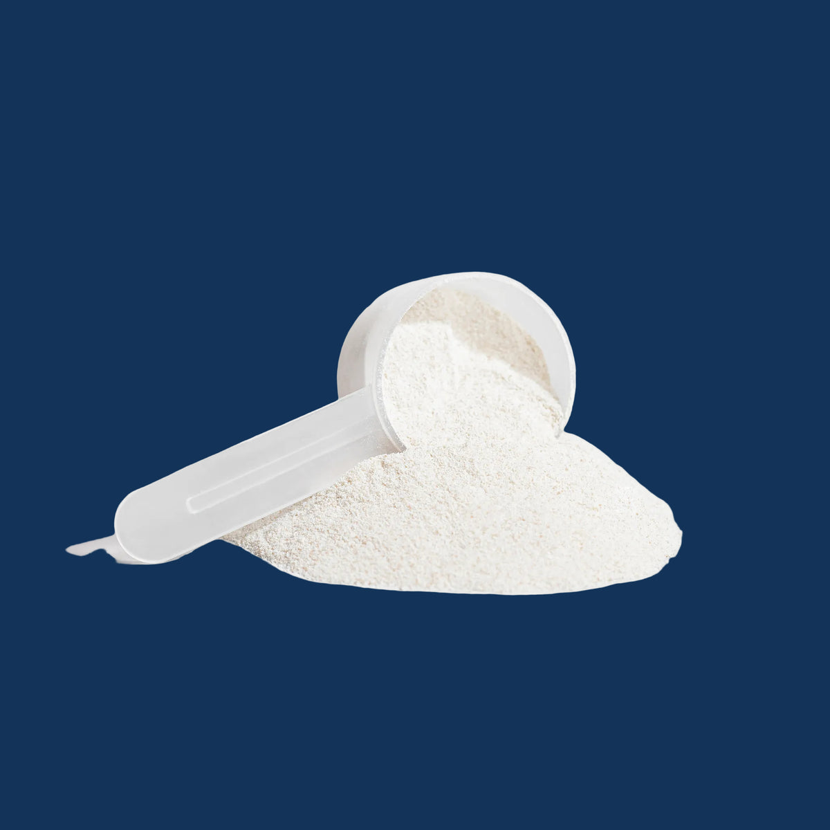 Grass-fed collagen peptides powder in a measuring scoop on a dark background.
